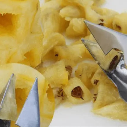 Close-up of Stainless Steel Fruit Tools - Peeling & Slicing Set tips removing pineapple eyes with sharp precision.