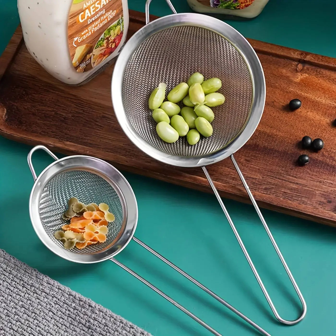 Durable Stainless Steel Strainer Set shown straining edamame and pasta, ideal for kitchen use with fine mesh for precise filtering.