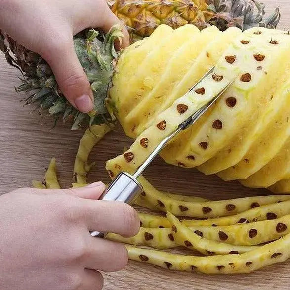 Hand using Stainless Steel Fruit Tools - Peeling & Slicing Set to remove pineapple eyes with precision and ease.