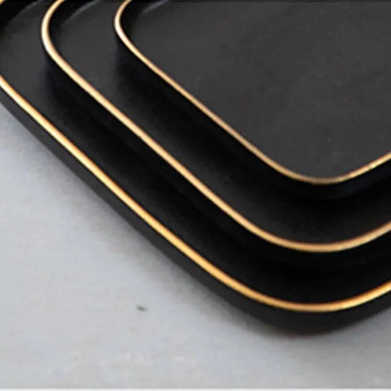 3 Size Black Dishes Set - Modern Dining Essentials featuring a close-up of stacked matte black plates with gold rims, ideal for contemporary dining.