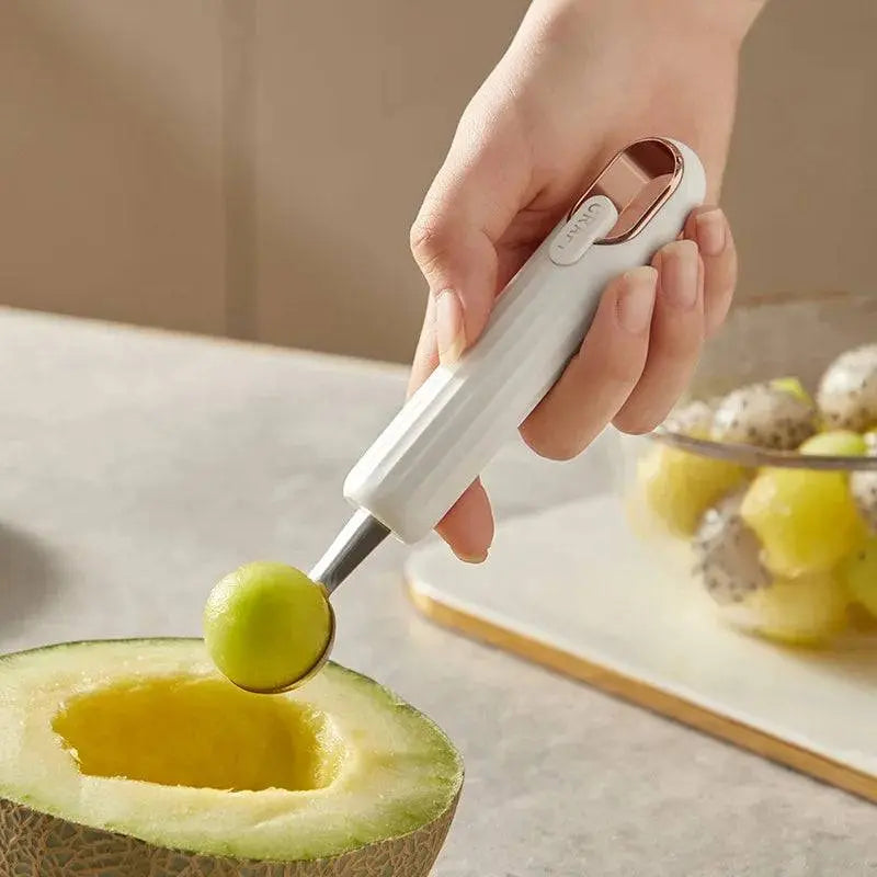 Stainless Steel Ball Scooper - Stainless Steel Scooper | Durable white-handled scooper lifting a melon ball, perfect for fruit preparation and desserts.