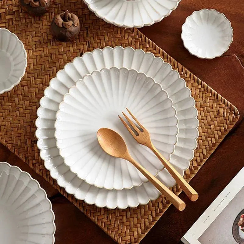 Close-up of white ceramic plates with scalloped edges from the elegant tableware set. Perfect for upgrading dining experiences with durable style.