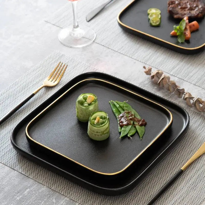 3 Size Black Dishes Set - Modern Dining Essentials featuring matte black ceramic plates with gold rims, elegantly presented with gourmet appetizers.