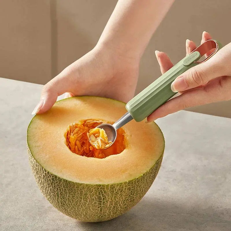 Stainless Steel Ball Scooper - Stainless Steel Scooper | Durable tool scooping seeds from a cantaloupe with a green handle, ideal for kitchen use.