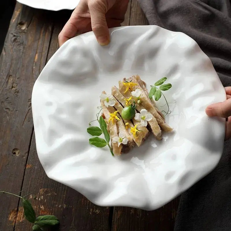 Hand holding White Ceramic Plate - Unique Design | Versatile & Easy-Clean, ideal for enhancing dining experiences with its sculptural form.