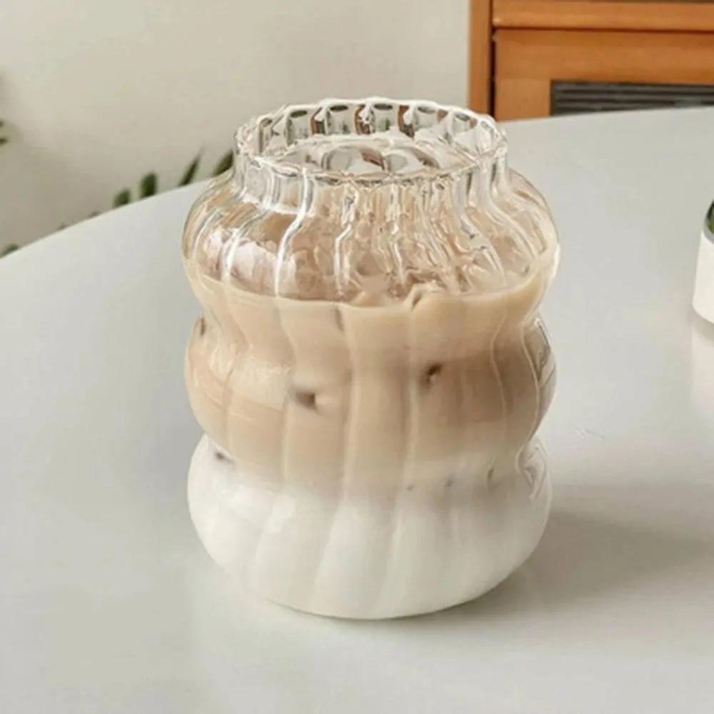 Ripple Drinking Glasses | Artistic Design Glasses with a close-up of a layered iced coffee drink in a wide, ribbed glass on a white surface.