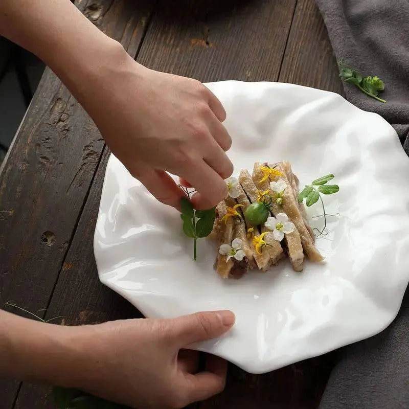 White Ceramic Plate - Unique Design | Versatile & Easy-Clean featuring a wavy textured surface, styled with gourmet food and floral garnish.