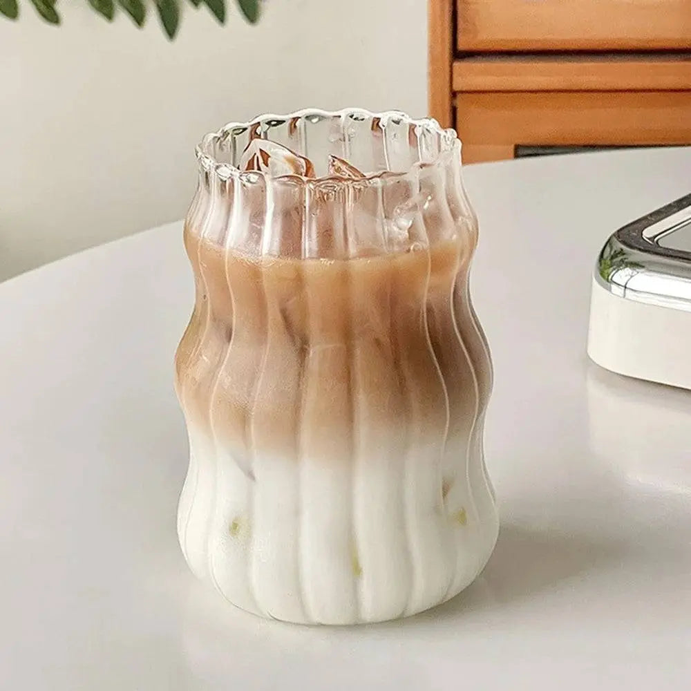 Ripple Drinking Glasses | Artistic Design Glasses showing a tall ribbed glass with a layered iced coffee drink on a white tabletop.
