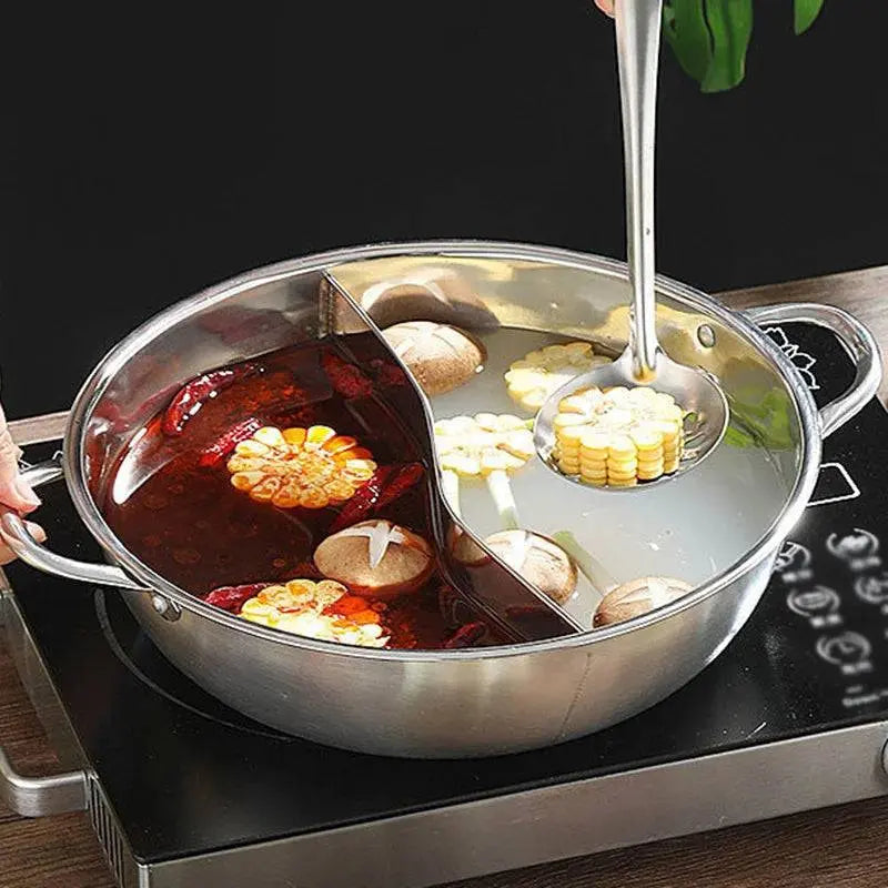Chinese Hot Pot - Stainless Steel 2-in-1 Cooker with a ladle scooping corn from the clear broth side, highlighting the dual-section design.