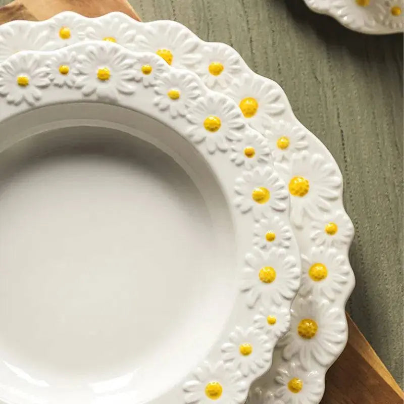 Close-up of the Ceramic Embossed Little Daisy Plate Dinner Set highlighting the intricate white and yellow daisy embossed design on the plates.