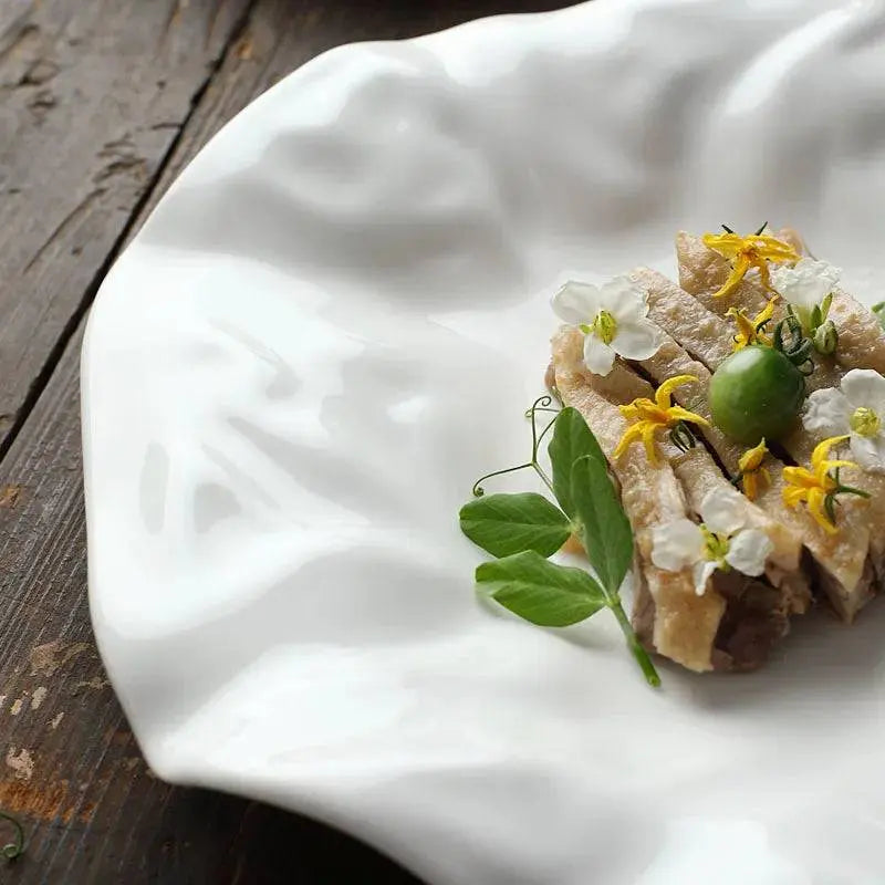 Close-up of White Ceramic Plate - Unique Design | Versatile & Easy-Clean with a glossy wavy finish, highlighting its artistic dinnerware appeal.