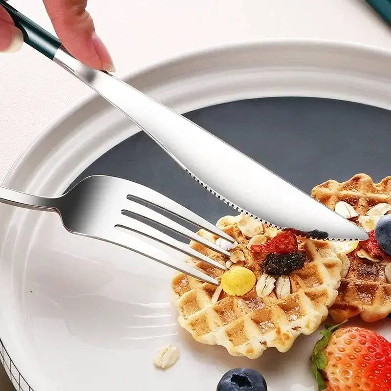 Close-up of stainless steel knife and fork from 4-Piece Portable Cutlery Set cutting waffles, showcasing travel dining convenience.
