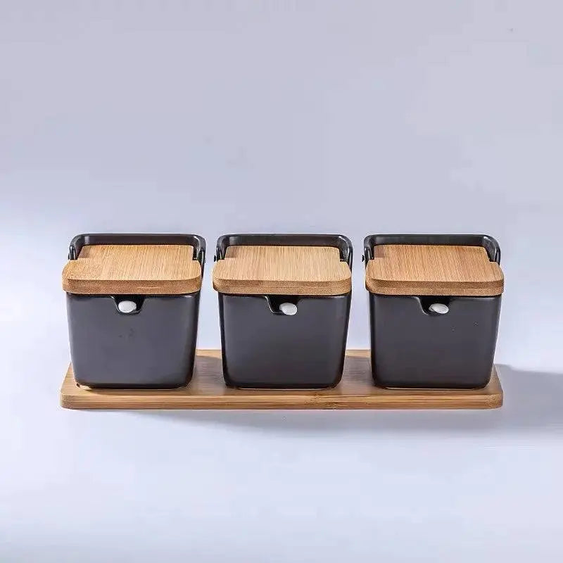 Minimalist Ceramic Spice Jar with Bamboo Lid | Compact & Airtight three black ceramic spice jars with bamboo lids on a bamboo tray.