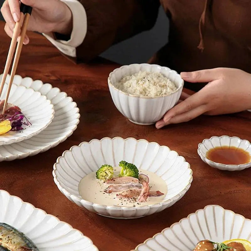Ceramic tableware set with white scalloped plates and bowls, ideal for serving rice, salads, and sauces. Dining essential for elegant meals.