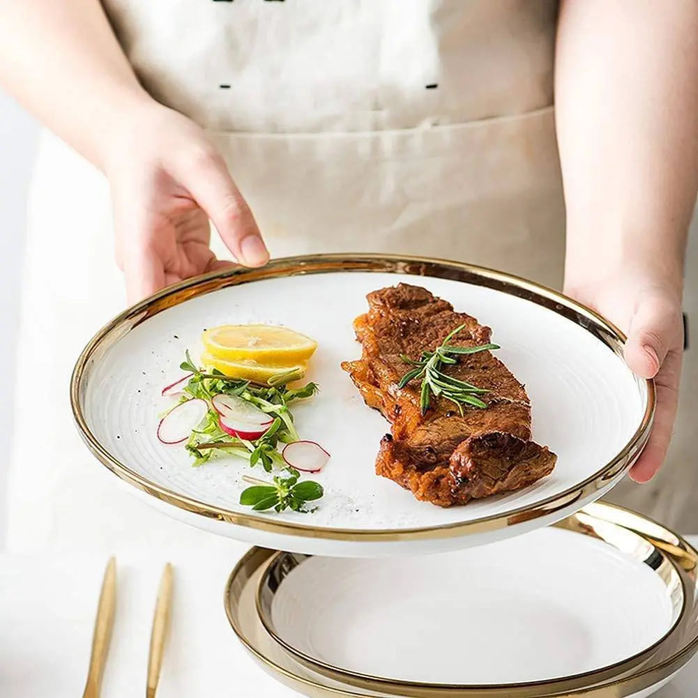 Premier Gold Ceramic Dinnerware Set - Elegant Dining | 12-Piece featuring a steak dish with lemon and greens on a white plate with gold rim.