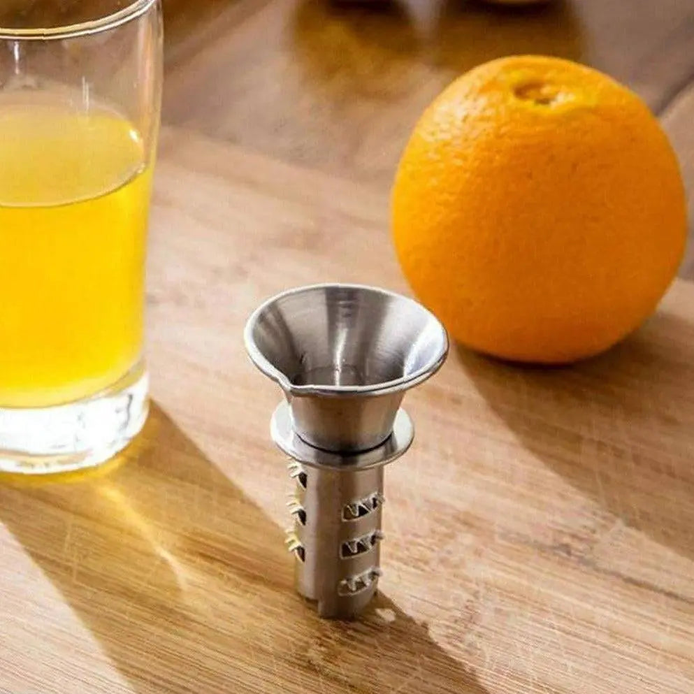 Handheld Lemon Squeezer - Easy Juicing | Durable Design placed on a wooden surface next to a glass of fresh juice and an orange, highlighting its compact size.
