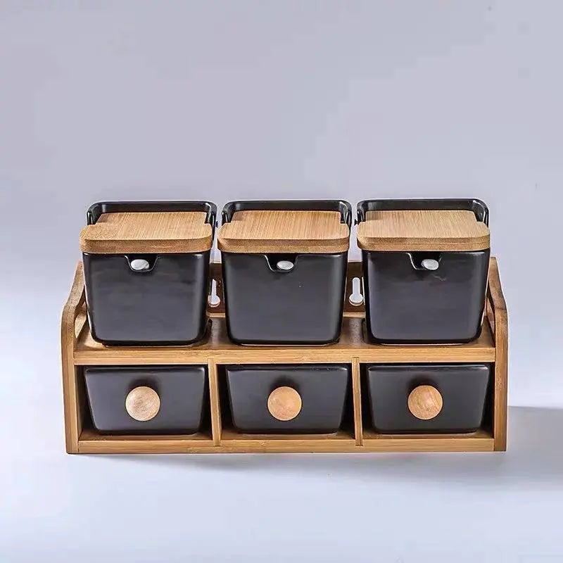 Minimalist Ceramic Spice Jar with Bamboo Lid | Compact & Airtight three black spice jars with bamboo lids on a wooden rack with drawers.