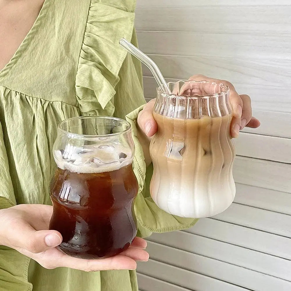 Ripple Drinking Glasses | Artistic Design Glasses held by a person in a green dress, displaying iced coffee and tea in stylish ribbed glasses.