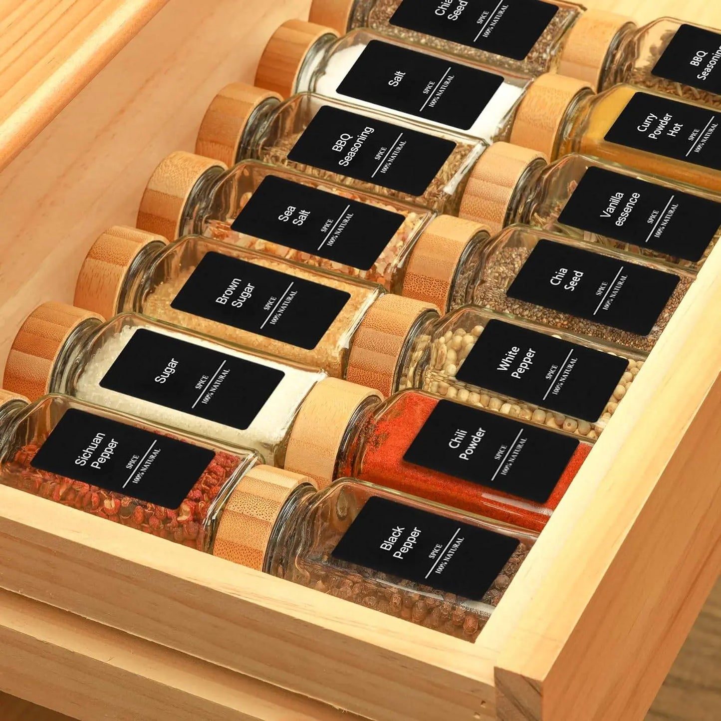 Glass Spice Jar Set with Bamboo Lids | Airtight, Clear Design arranged in a wooden drawer, displaying labeled spices like sugar, salt, and curry powder.