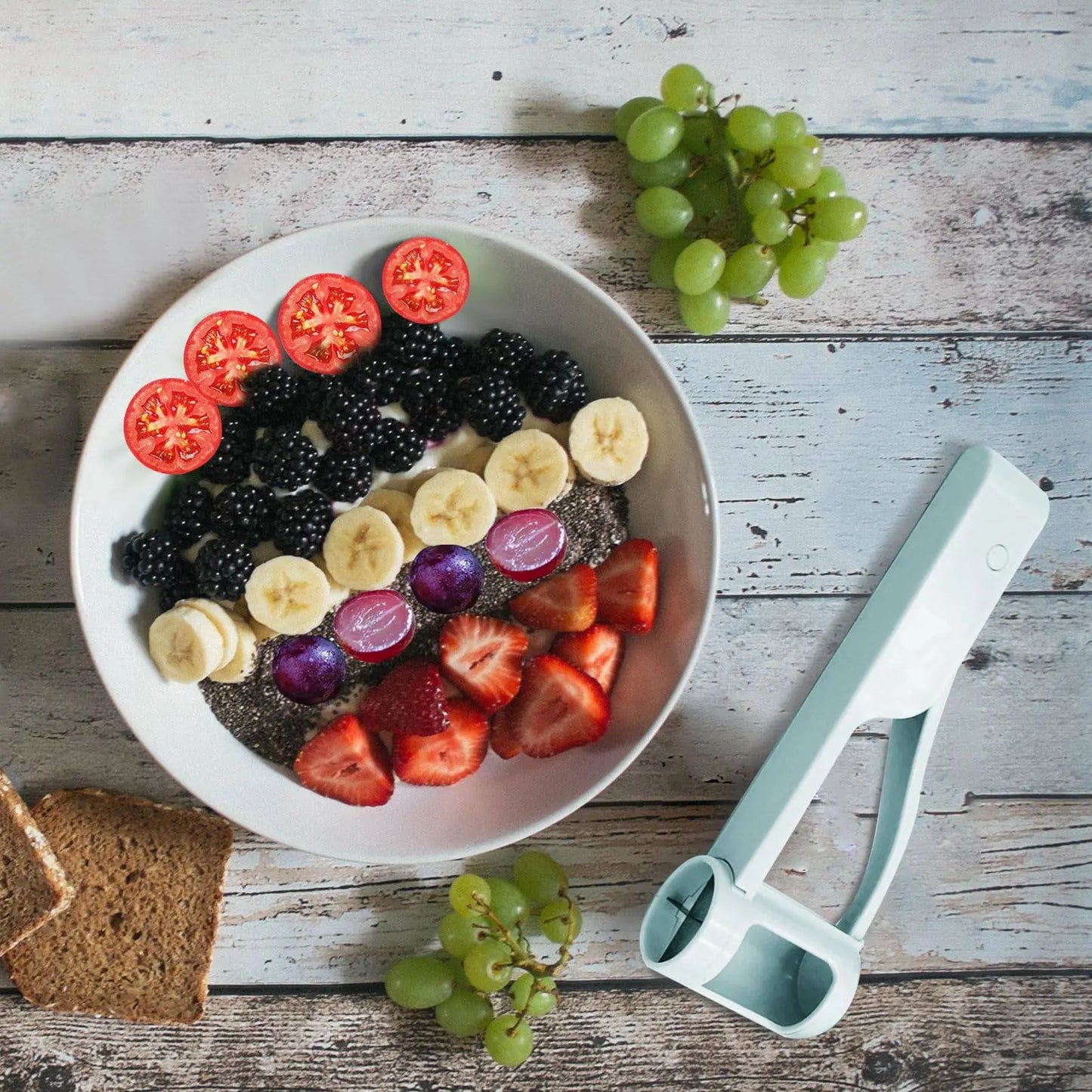 Handy Grape Cutter - Grape Cutter Tool | Safe Fruit Slicer shown next to a fruit bowl with sliced grapes, strawberries, and tomatoes.