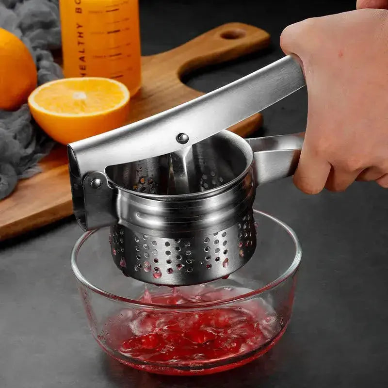 Stainless Steel Manual Juicer - Multifunctional | Compact Design pressing red fruit juice into a glass bowl, durable and easy to clean.