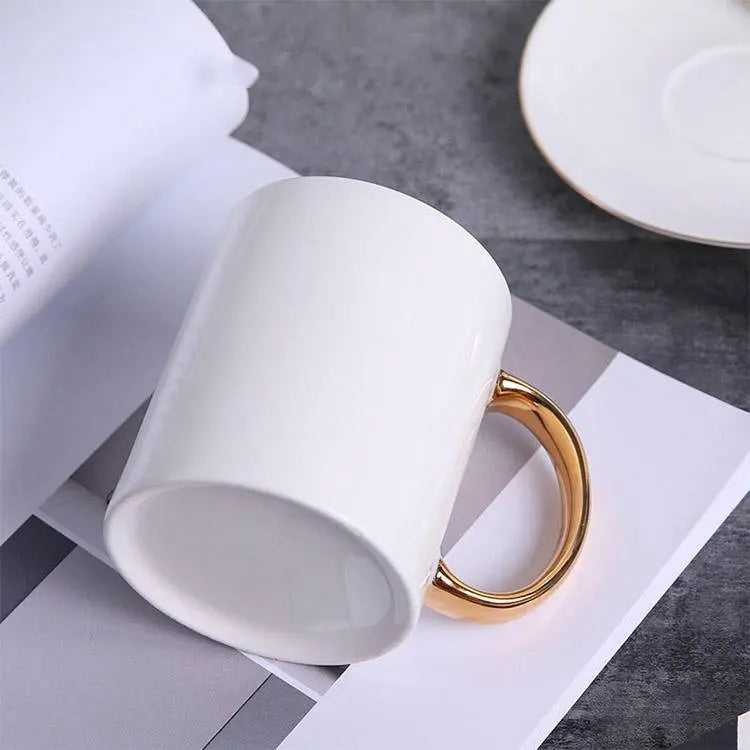 Elegant Coffee Cup with Gold Handle resting on an open magazine, blending modern design with everyday coffee indulgence.