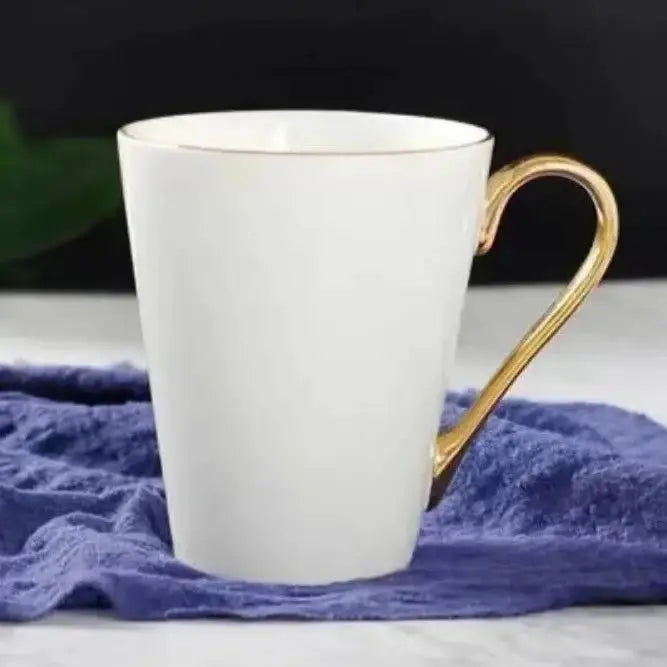 Tapered Elegant Coffee Cup with Gold Handle on a blue cloth, showcasing a refined and stylish silhouette for elegant coffee enjoyment.