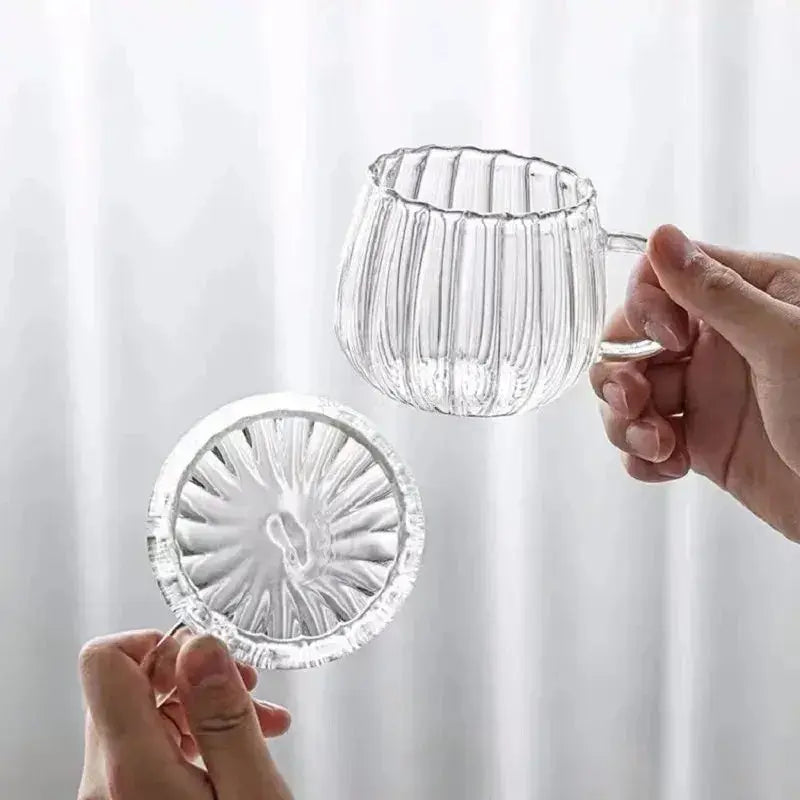Hand holding Heat-Resistant Striped Glass Mug and saucer showcasing clear ribbed design. Lightweight and durable heat resistant glass mug.