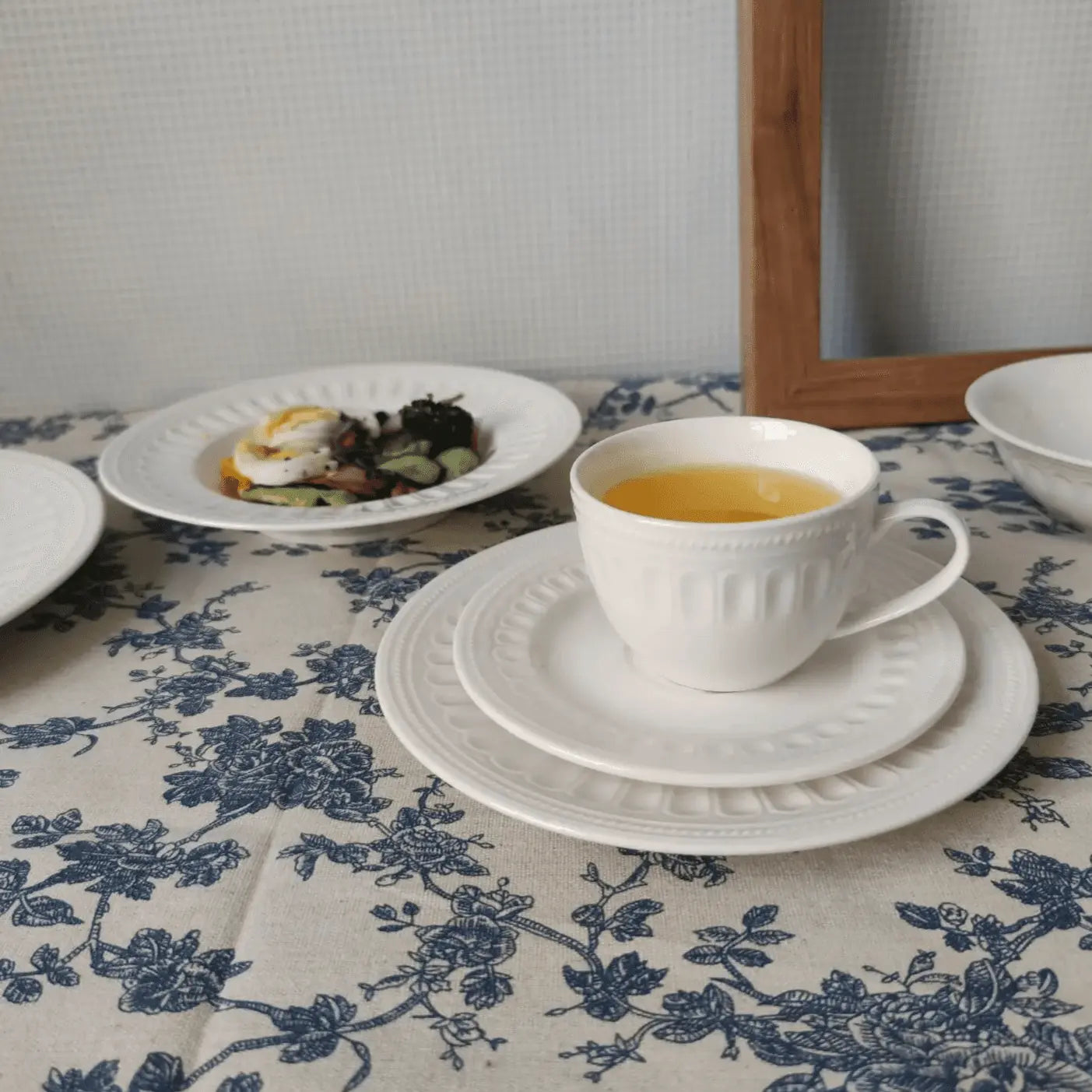 Charlotte Mug Set - Stylish & Durable Mugs | Microwave Safe, featuring a white mug with tea on a patterned tablecloth alongside elegant plates.