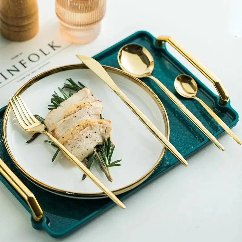 24-piece golden cutlery set displayed with a festive meal on a green tray, perfect for holiday table settings.