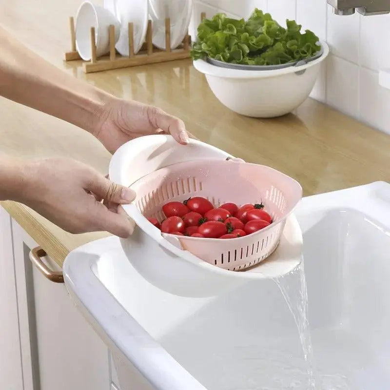 Rotatable Double Drain Basket - Efficient Kitchen Tool tilted to drain water while washing tomatoes, ideal for kitchen efficiency.