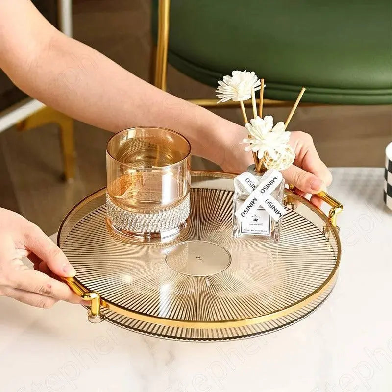 Elegant Round Plastic Tray with gold handles being held, showcasing its stylish and modern design for serving and decor purposes.