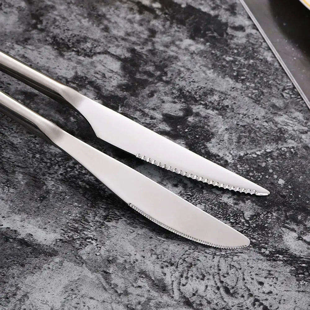 Close-up of serrated knives from the 304 Stainless Steel Dinnerware Set - Timeless Dining, highlighting precision and craftsmanship.
